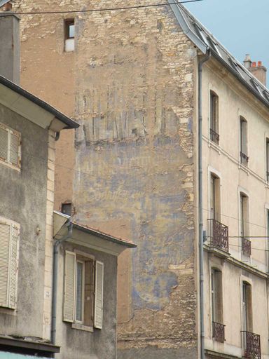  mur d'immeuble avec traces d'ancienne publicité